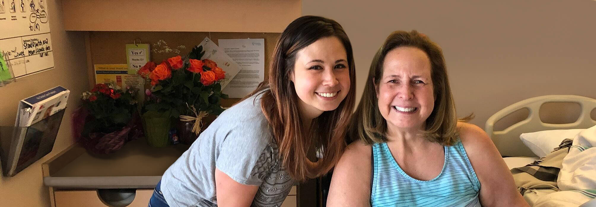 Mother and daughter smiling to the camera in a hospital room