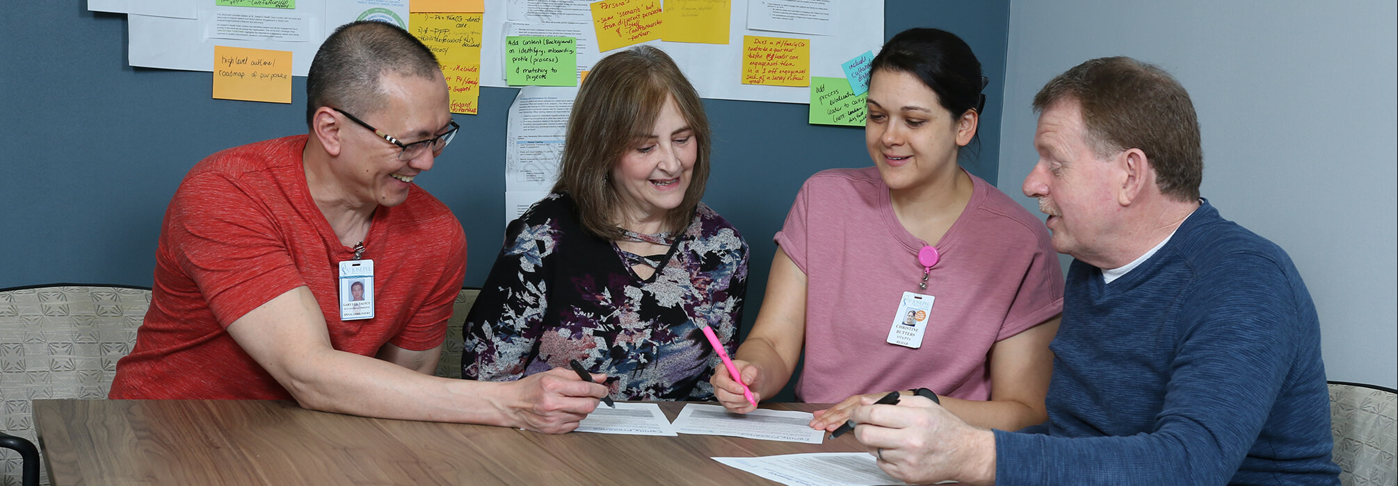 Four team members sitting round a table collaborating on a document